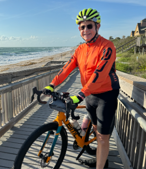 Bill Penney riding his bike at the beach.
